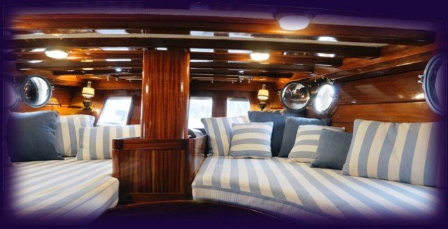 Boat interior with striped upholstery and rich wood cabin details