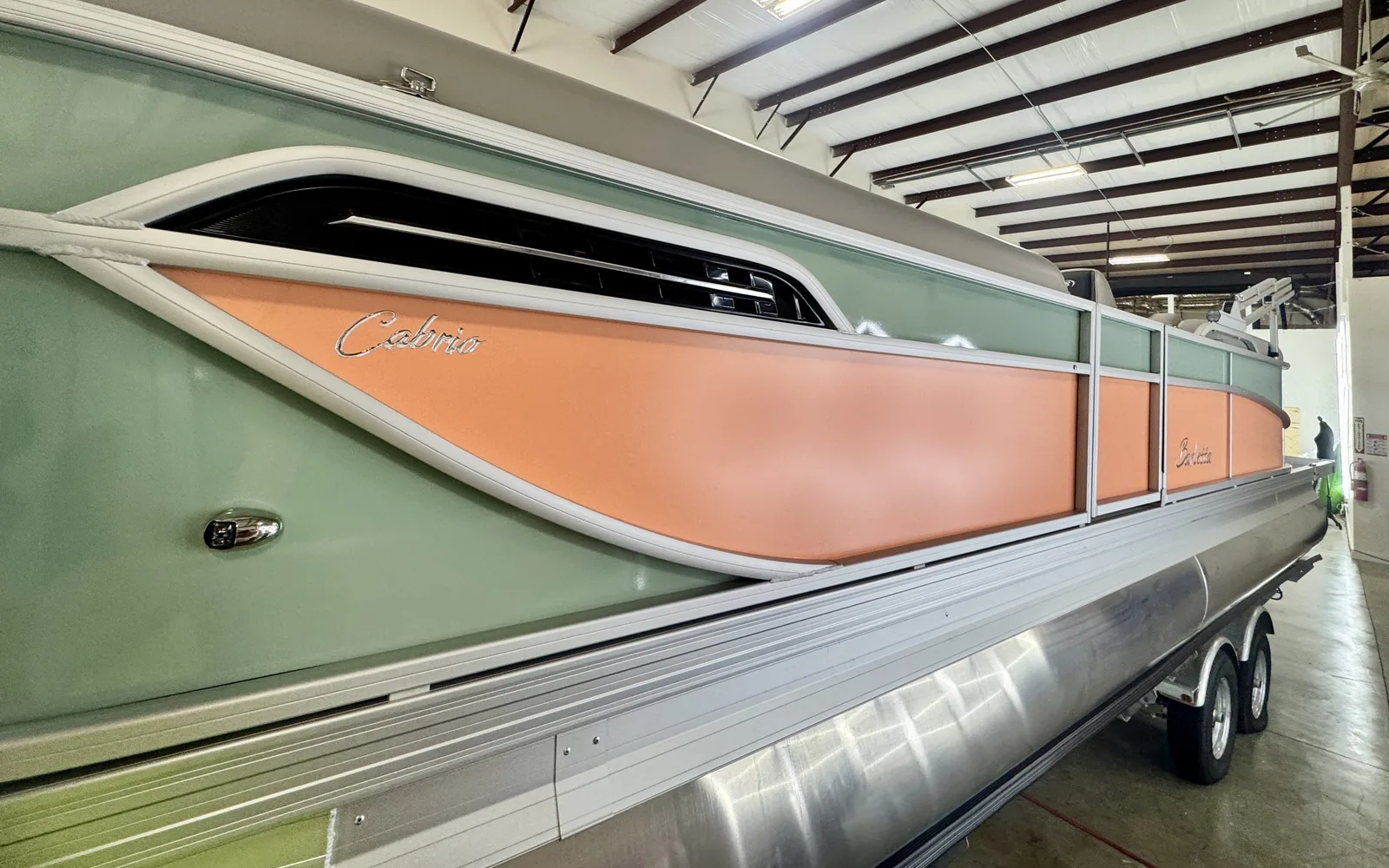 Barletta Cabrio pontoon with sage green and coral panel wrap by Vinyl Alchemy