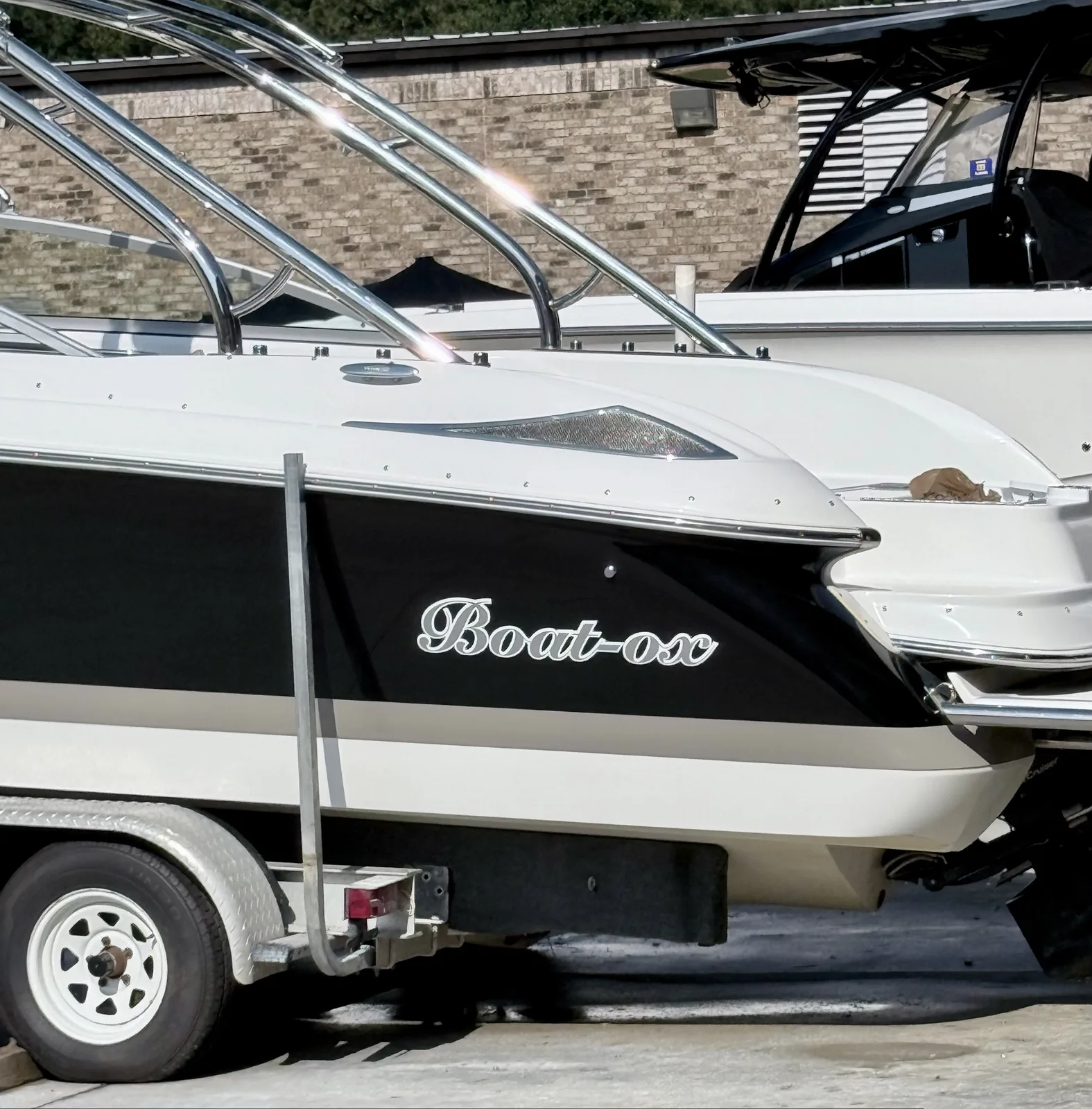 Boat-ox script name with outline on a dark hull stripe