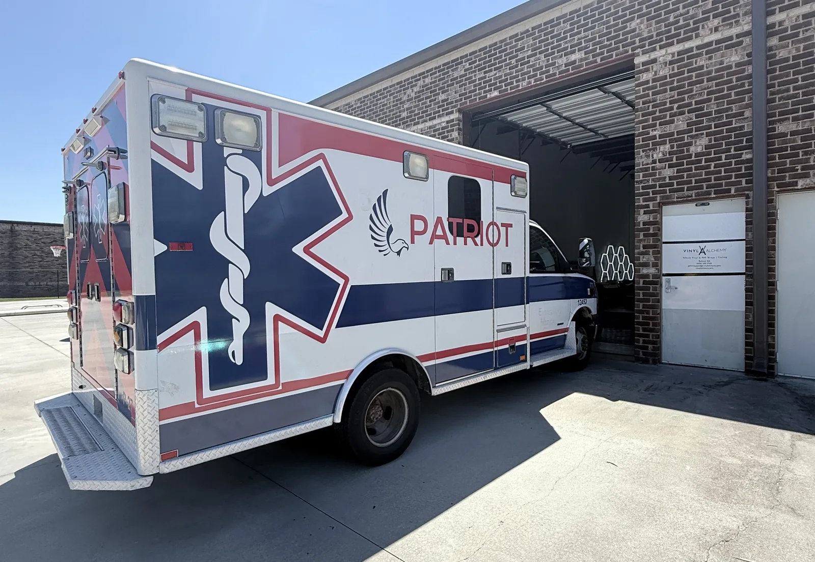 Patriot EMS box ambulance with matching fleet graphics at the Vinyl Alchemy facility