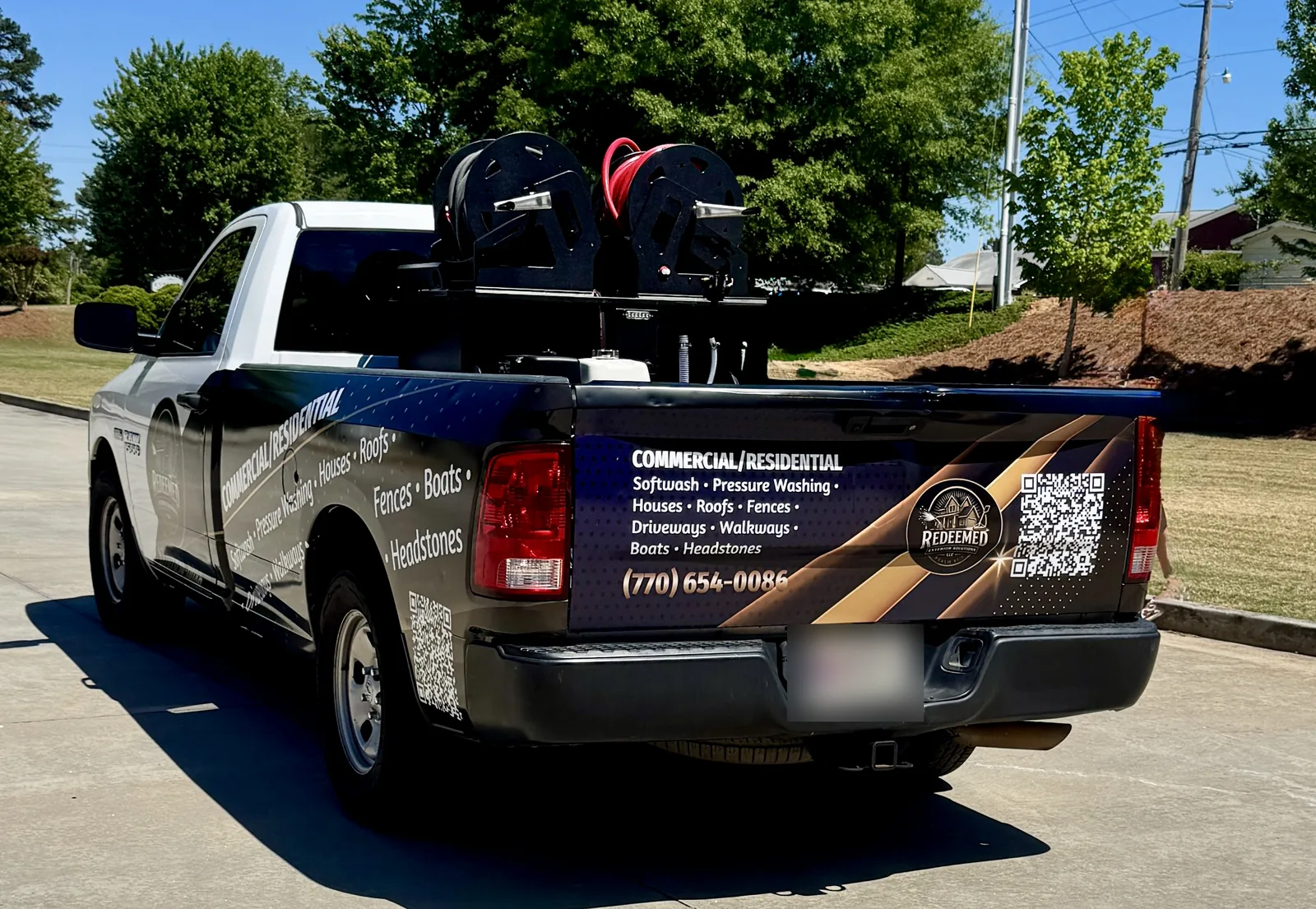 Redeemed Exterior Solutions pickup with partial wrap, service menu, and QR codes